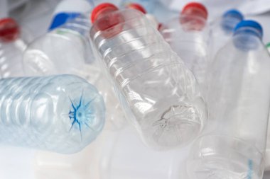 Saydam plastik şişelerin farklı renklerde kaplamalı fotoğraflarını kapat, plastik kirliliği kavramı