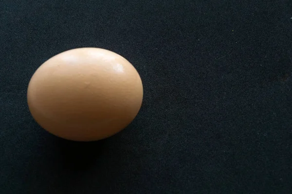 Один Большой Коричневый Вид Сверху Яйца Изолирован Черном Фоне — стоковое фото