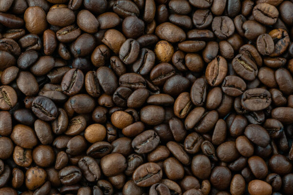 Brown roasted coffee beans in the whole photo background