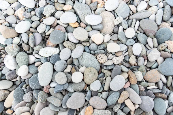 Koyu ve açık gri taşların yakın plan fotoğrafı deniz kenarında, üst tarafta. Dokulu doğal arkaplan