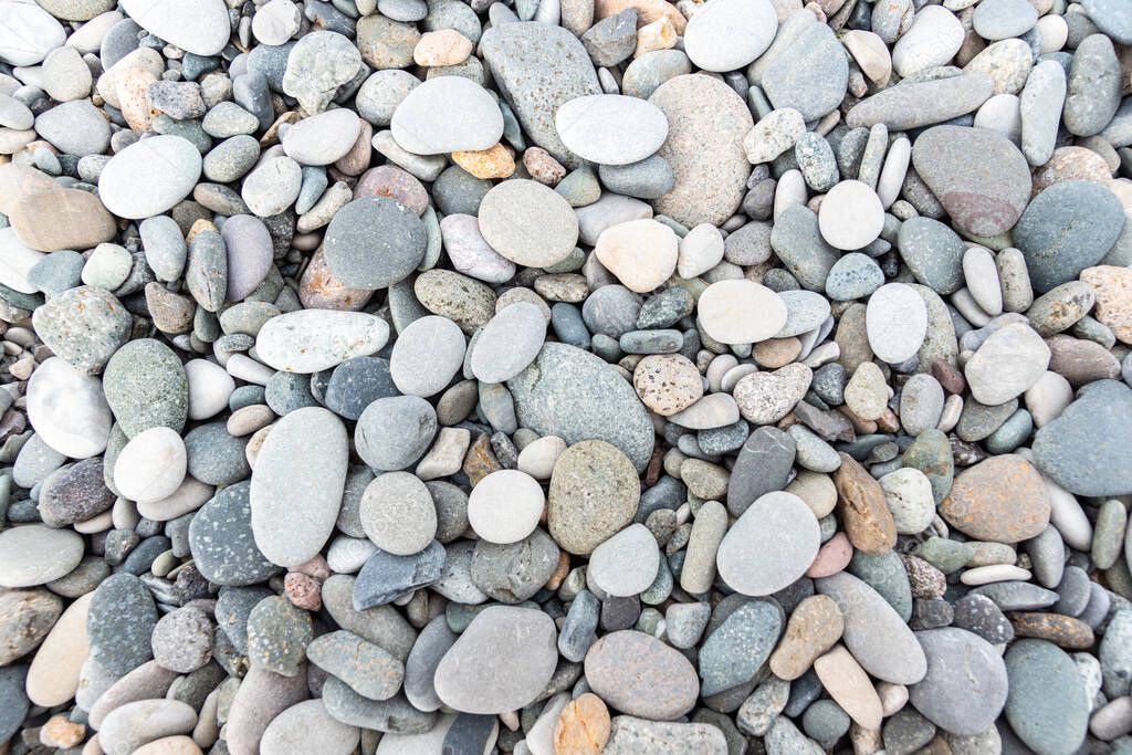 close up photo of dark and light gray stones lie on seaside, top view. Textured natural background