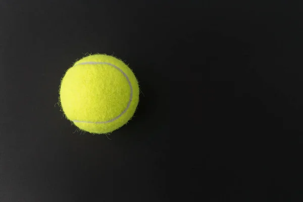 黒の背景に黄色のテニスボールのイメージを閉じます テキストのためのスペース スポーツ活動 — ストック写真