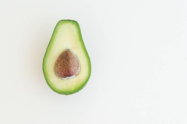 Avokado 'nun yarısı açık turuncu arka planda, metin için boşluk, sağlıklı gıda konsepti, diyet ve detoksifikasyon