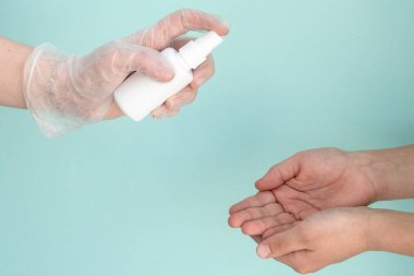 Tıbbi eldiven, beyaz bir şişe antibakteriyel antiseptikle el ele tutuşması için antibakteriyel dezenfektanı, salgın, virüsler, sararlar, koronavirüs, sağlık konsepti.