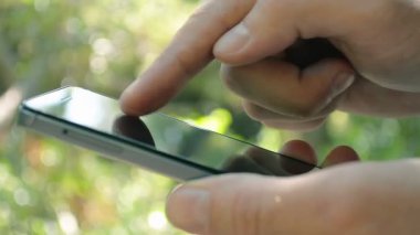 Parkta bir akıllı telefon kullanan adamı kapatın