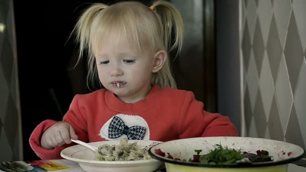 Dolly Girl Eating Porridge at home Alone at a table in the Kitchen — Stock Video