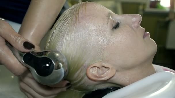 Close Up Стилист мыть волосы с шампунем молодая девушка — стоковое видео