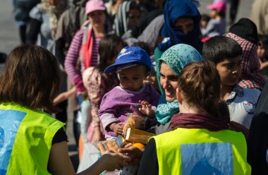 Suriye kadın oğluyla bir mülteci kampında hayırsever kuruluşlardan suyu ve portakal almak  