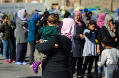 Suriyeli mülteciler için bir çadır kampında kollarında küçük oğlu kadınla
