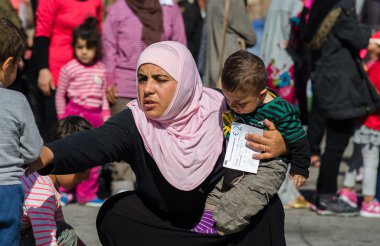Suriye kadın kollarında Suriyeli mülteciler için bir kampta küçük oğlu ile 