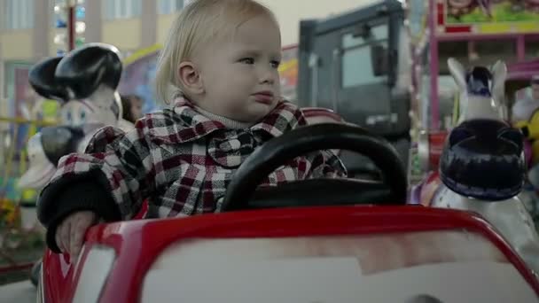 Kind rijden op een carrousel in pretpark — Stockvideo