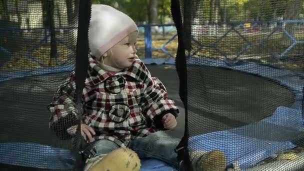 Niño saltando en un trampolín para niños al aire libre — Vídeos de Stock