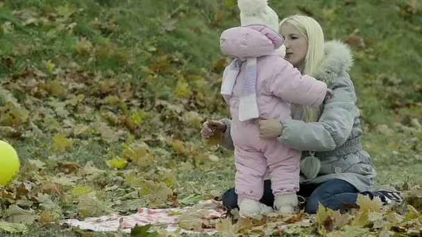 Egy kis gyerek kint a parkban játszó fiatal anya — Stock videók