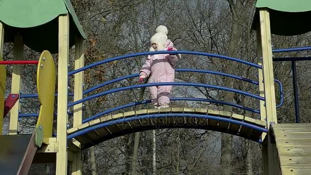 Muñeca niña jugando sola en el parque infantil en el parque — Vídeo de stock