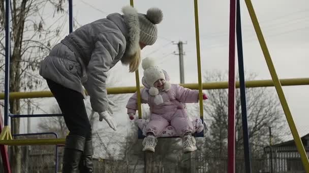 Dolly madre con una hija jugando en el patio de recreo — Vídeo de stock