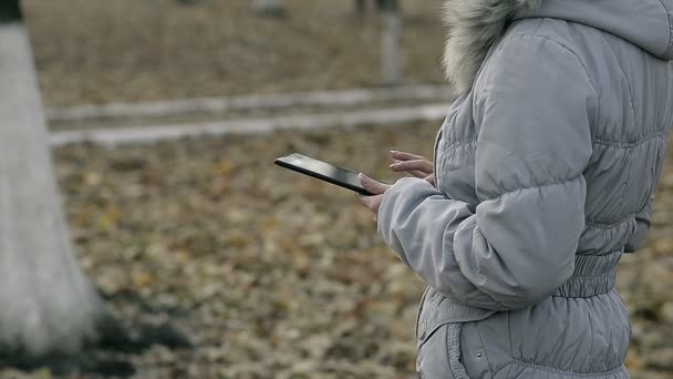 Dolly Close Up Girl avec une tablette dans le parc — Video