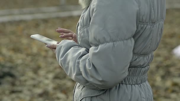 Dolly dicht omhoog jong meisje met een telefoon in Park — Stockvideo