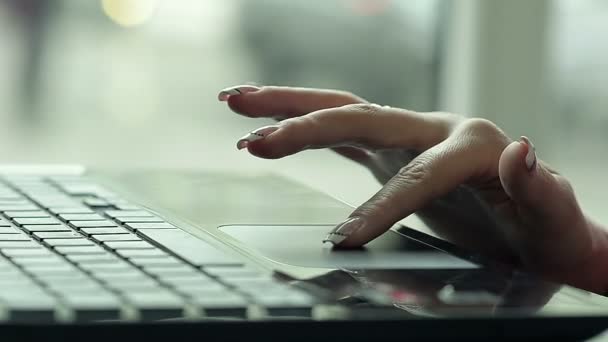 Primer plano de una mano femenina usando una computadora portátil en un café — Vídeo de stock