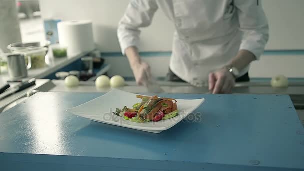 Chef en la cocina plato de verduras cocidas con carne en el restaurante — Vídeos de Stock
