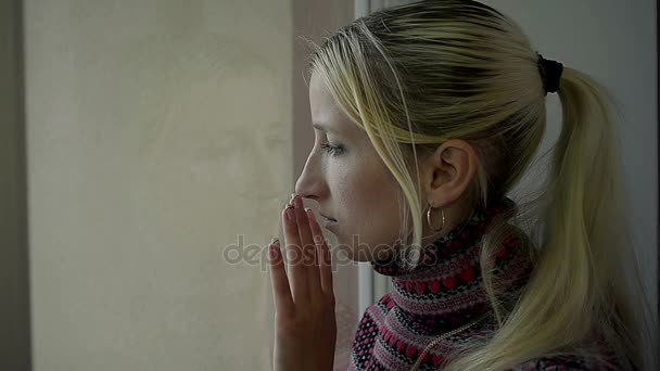 Sfrustrowany młody dziewczyna patrząc w okno w domu — Wideo stockowe