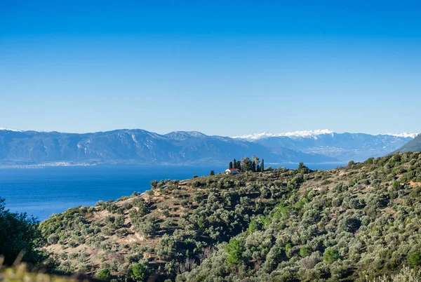 Hus på en kulle med fantastisk utsikt över bergen och sjön — Stockfoto