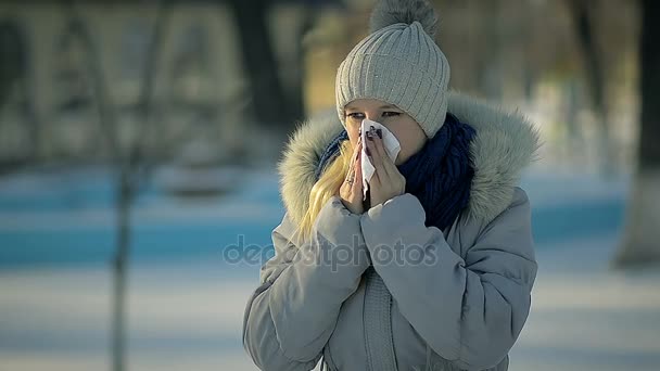 关闭了生病的女孩吹她的鼻子在冬季公园 — 图库视频影像