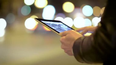 Genç adam gece şehirde Tablet kullanma