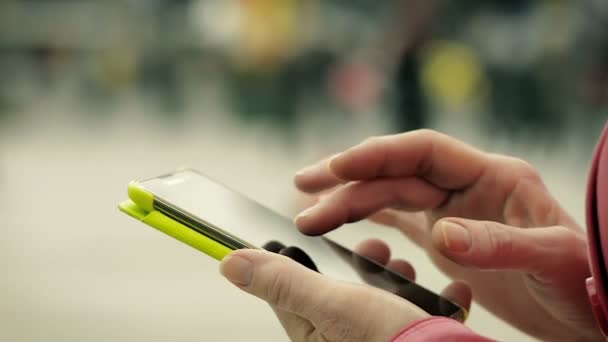 Primer plano de una mano femenina usando un teléfono inteligente en la ciudad — Vídeo de stock