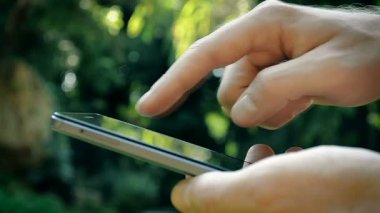 Erkek el parkta bir akıllı telefon kullanma