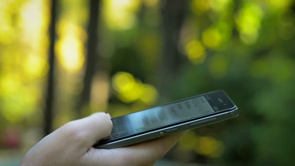 Mujer usando un teléfono inteligente en el parque — Vídeo de stock