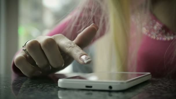 Жіноча рука використовуючи смартфон у кафе біля вікна — стокове відео