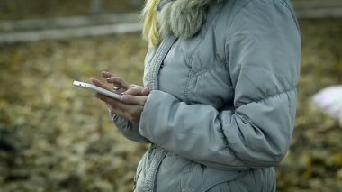 Yakın çekim genç kız parkta bir akıllı telefon ile