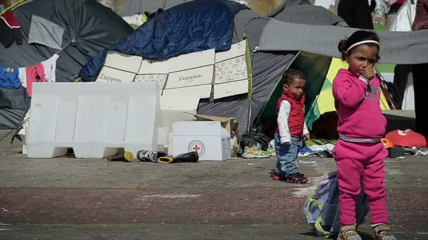 Athens 12. april: kleine kinder syrischer flüchtlinge gehen in ein flüchtlingslager 12. april 2016 in athens. — Stockvideo