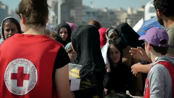 Athens 12. april: karitative organisation rotes kreuz verteilt an flüchtlinge nahrung und wasser in einem flüchtlingslager im griechischen hafen 12. april 2016 in athens. — Stockvideo