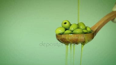 Zeytinyağı bir tahta kaşıkla zeytin damlayan