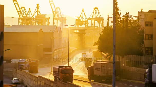 Camiones en la carretera que conducen al puerto de carga en la puesta del sol — Vídeo de stock