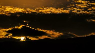 Bulutların arasından dağlar arkasından güneş doğuyor 