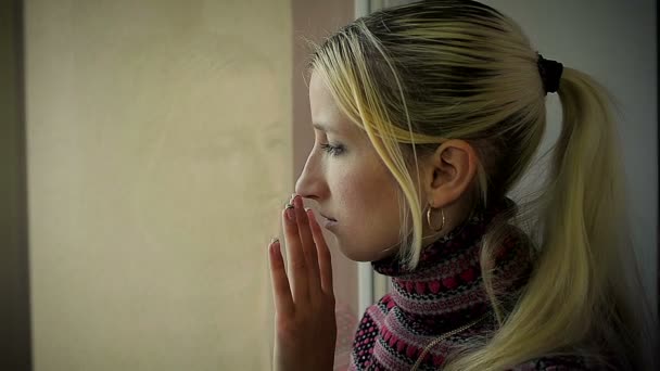 Zbliżenie sfrustrowany młoda dziewczyna patrząc przez okno — Wideo stockowe