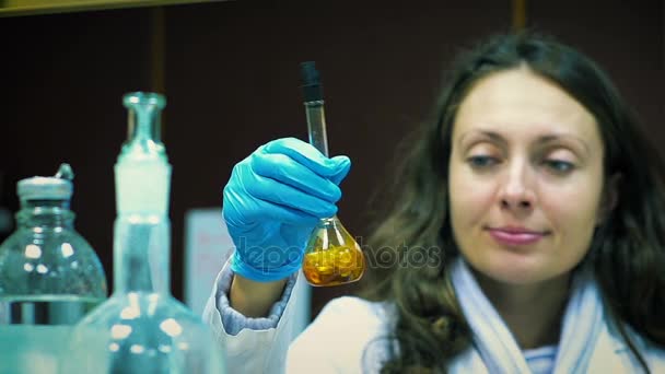 Ученый проводит биохимические исследования вирусов в испытательных трубах в лаборатории — стоковое видео