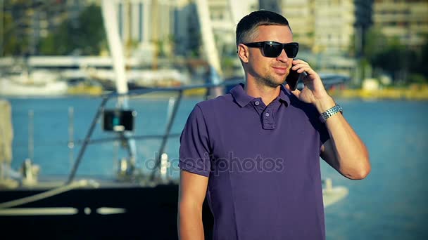 Homem conversando no telefone inteligente em um descanso na Marina — Vídeo de Stock