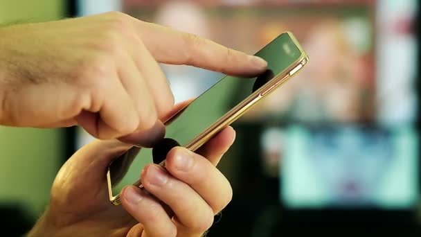 Nahaufnahme einer männlichen Hand mit einem Smartphone zu Hause — Stockvideo