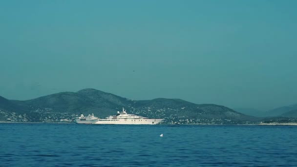 Bateau de luxe flotte au bord de la mer près d'une île vue — Video