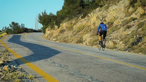 Résumé Un cycliste se rend au sommet de la montagne sur la route — Video