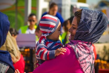 Mutlu Suriye anne kucağında küçük bebeği bir mülteci kampında tutar..