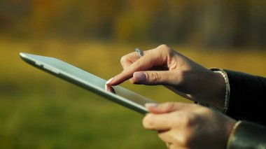 Açık havada tablet kullanarak yakın çekim el