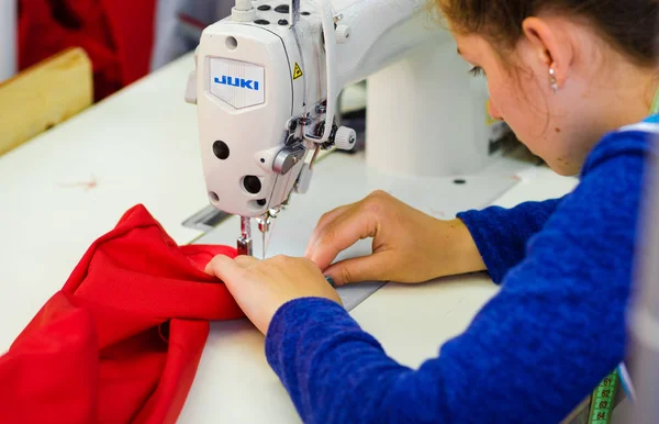 Close-Up menina costura roupas na fábrica de vestuário — Fotografia de Stock