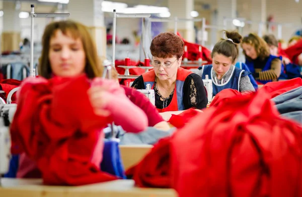 Trabajadores cosiendo ropa en fábrica de prendas de vestir —  Fotos de Stock