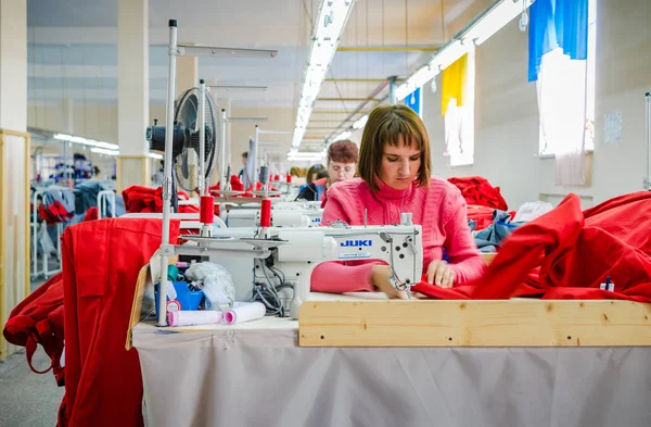 Grupo de trabajadores de la fábrica cosiendo ropa en la fábrica de prendas de vestir —  Fotos de Stock