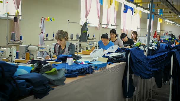 Groupe de travailleurs d'usine coudre des vêtements de jeans dans l'usine de vêtements — Video