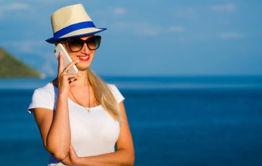 Yakın çekim bir dinlenme Sahilde akıllı telefonla konuşurken bir genç kız